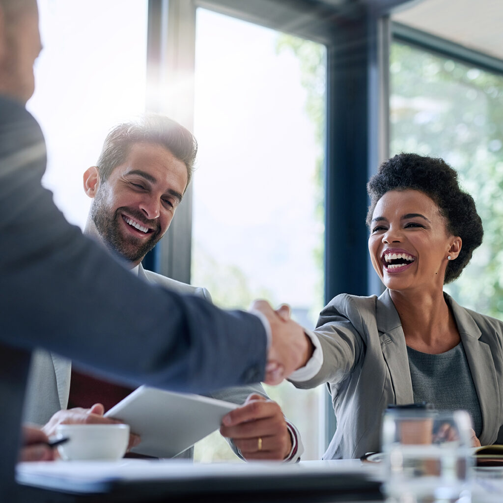 Staff Augmentation - Meeting, partnership and business people shaking hands in the office for a deal, collaboration or onboarding. Diversity, professional and employees with handshake for agreement, welcome or greeting.